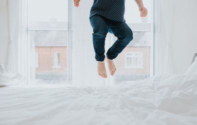 Child jumping on bed