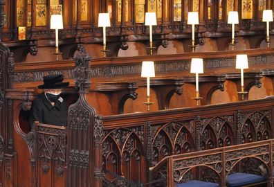 (EDIT) Queen Elizabeth II takes her seat during the funeral of Prince Philip, Duke of Edinburgh in St George's Chapel at Windsor Castle on April 17, 2021 in Windsor, England. Prince Philip  married the then Princess Elizabeth on 20 November 1947. He served as Prince Consort to Queen Elizabeth II until his death on April 9 2021, months short of his 100th birthday. only 30 guests invited due to Coronavirus pandemic restrictions. 