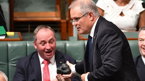Scott Morrison hands Barnaby Joyce a lump of coal in parliament.