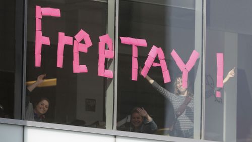 Workers put up sign in support of pop singer Taylor Swift in an office building across the street from the federal courthouse in Denver. (AAP)
