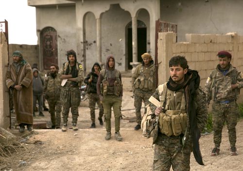 US-backed Syrian Democratic Forces fighters wait to go to the front line to oust Islamic State militants from Baghouz, Syria, in a photo dated March 14, 2019.