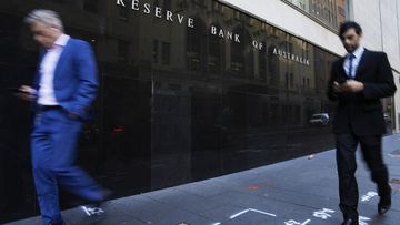 A woman walks past the outside of the Reserve Bank in Sydney, Australia.