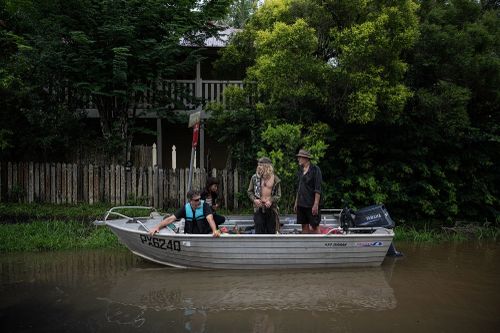 Riverside flooding at Lismore. Locals in a boat have a look at the flood levels caused by ex-Tropical Cyclone Alfred.