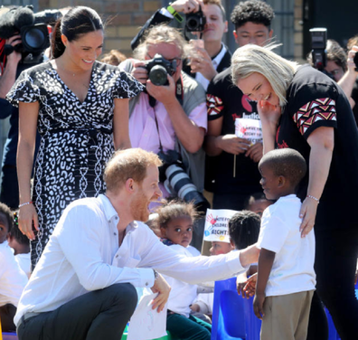 Prince Harry shares a laugh with a shy little boy in Nyanga.