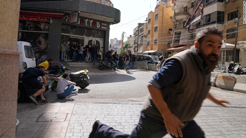 A man runs for cover as gunfire breaks out at a protest in Beirut, Lebanon. 
