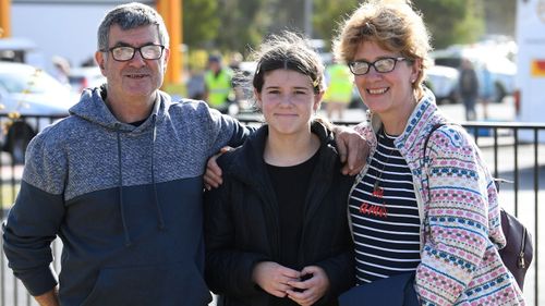 Mallacoota bushfire evacuees (L-R) Ron and Olivia and Lisa Short pose for a photo after arriving at the Somerville Recreation Centre in Somerville south-east of Melbourne, Saturday, January 4, 2019.