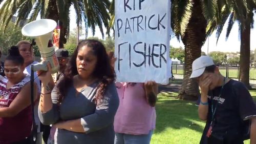 The protesters were holding placards and photos of Mr Fisher. (9NEWS)