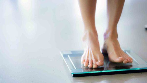Woman weighing herself on scales