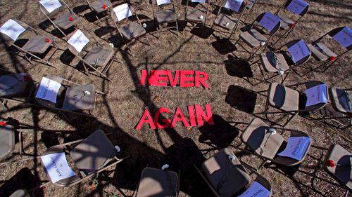 Two rings of chairs encircle the words "never again" in a silent protest on this year's 19th anniversary of the Columbine High School shooting outside Trinity High School in Manchester, New Hampshire. 