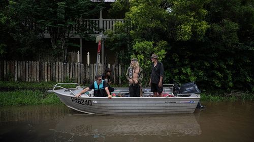 Inundações ribeirinhas em Lismore. Moradores em um barco observam os níveis de inundação causados ​​pelo ex-ciclone tropical Alfred.