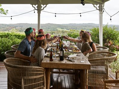 Family outside on deck celebrating Christmas over a meal. 