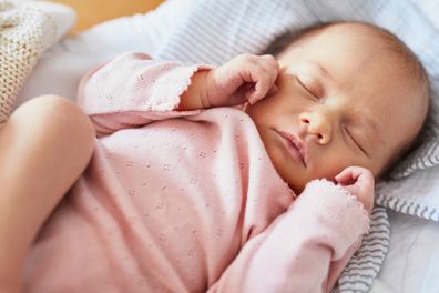 Newborn baby girl sleeping peacefully in the crib