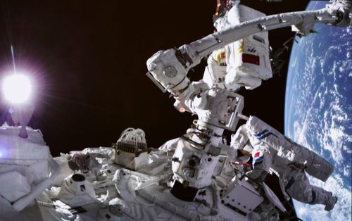 Chinese astronauts Cai Xuzhe, top and Chen Dong conducting extravehicular activities.