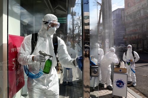 Disinfection professionals wearing protective gear spray anti-septic solution against the coronavirus (COVID-19) on February 27, 2020 in Seoul.