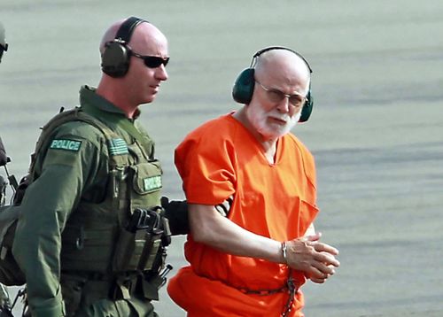 In this 2011 file photo James ‘Whitey’ Bulger, right, is escorted from a US Coast Guard helicopter to a waiting vehicle at an airport in Plymouth. Picture: AP