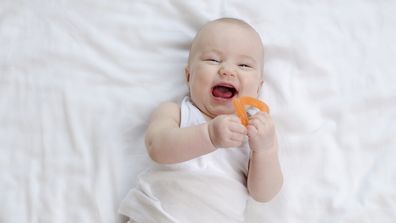 A happy baby with a teether