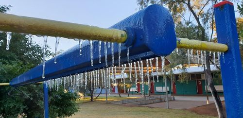 Play equipment at Ross Park Primary School had frozen tendrils due to the low overnight temperatures in the Top End.