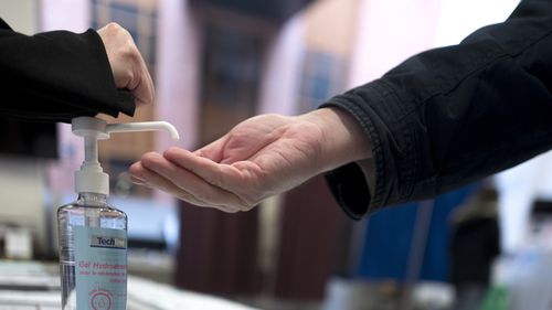 A man washes his hands during the first round of the municipal elections, in Lille, northern France, Sunday March 15, 2020. 