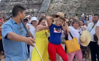 A woman had water and bottles thrown at her after she climbed and danced on a Mayan pyramid in Mexico.