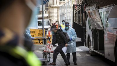 A man is transported out of the Brady Hotel, Melbourne. The hotel is one of the hotels used to isolate those who test positive to COVID-19.