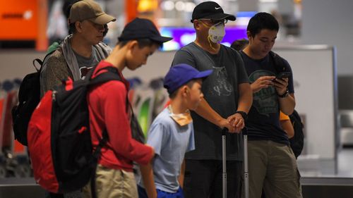 Australian evacuees who were quarantined on Christmas Island over concerns about the COVID-19 coronavirus collect baggage at Sydney Airport in Sydney, Monday, February 17, 2020. The bulk of the people quarantined on Christmas Island have been flown to the mainland on two aircraft while about 35 people will return the day after tomorrow. 