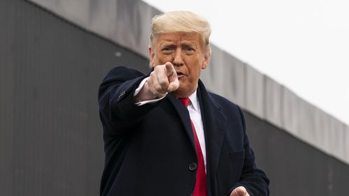 US President Donald Trump points to a member of the audience.