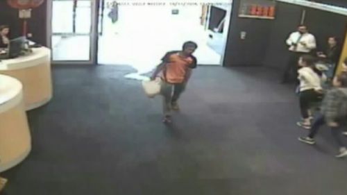 CCTV showed a man walking into the bank with a container of fuel. (9NEWS)