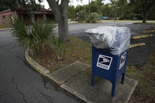 Un film plastique ferme une boîte aux lettres à l'extérieur du bureau de poste de Steinhatchee, en Floride, avant l'arrivée prévue de l'ouragan Idalia, le mardi 29 août 2023.