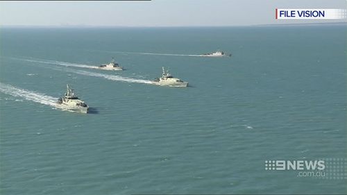 Australian naval and customs ships move in on a smuggling vessel. (9NEWS)