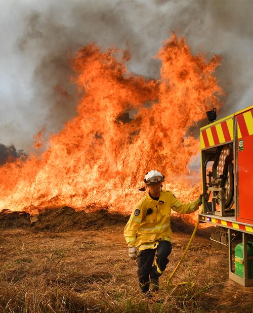New South Wales Rural Fire Service firefighters are seen back burning and fighting fires on Long Gully Road in the northern New South Wales town of Drake, Monday, September 9, 2019. 