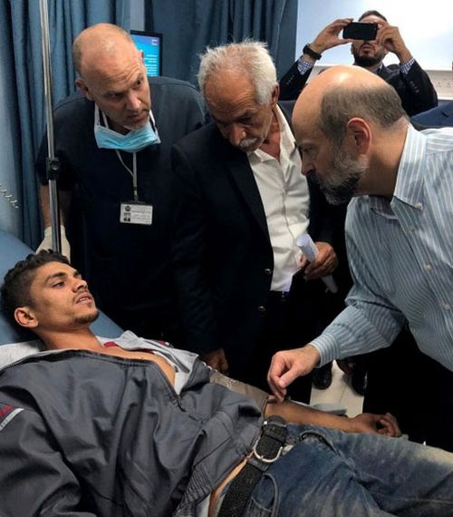 Jordan's Prime Minister Omar al-Razzaz, right, visits the injured flood victims in hospital. 