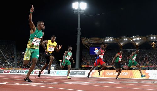 Akani Simbine crosses the finish line to win gold. (Getty)