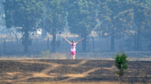 A local resident surveys her property after the fast moving Kilmore bushfire. (AAP)