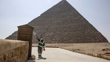 Municipal workers sanitize the areas surrounding the Giza pyramids complex in hopes of curbing the coronavirus outbreak in Egypt, Wednesday, March 25, 2020. 