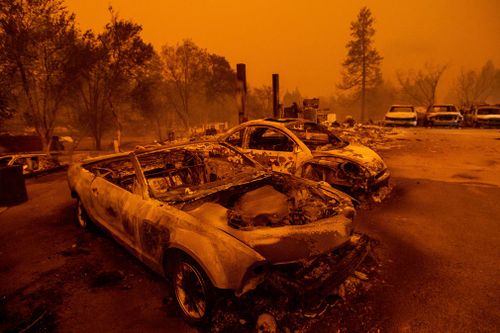 Scorched vehicles line a used car dealership after a wildfire burned through Paradise.