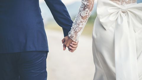 Close up of married couple holding hands in wedding day