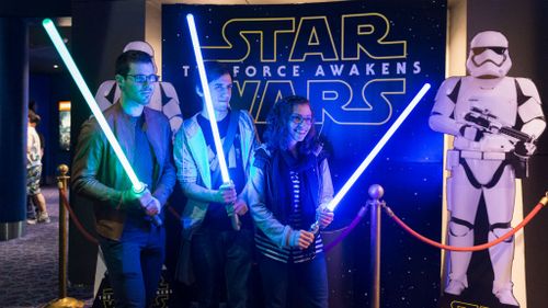 Fans pose in front of the movie sign before the Star Wars: The Force Awakens, screening in Sydney. (AAP)