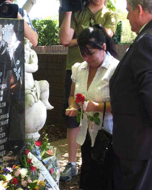 Tina (left) and Barry Gobbe (right) lay flowers at the Granville train disaster memorial plaque in western Sydney on Sunday, Jan. 18, 2009.