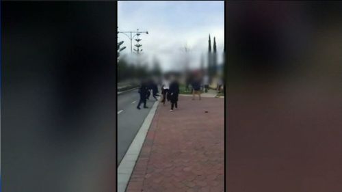 Dozens of children were fighting outside the school. 