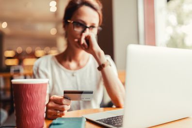 Woman in a cafe having problems with her credit card.