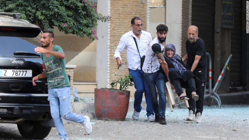 Men help an elderly woman evacuate the area.