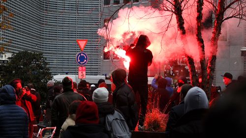 A protester lights a flare during a demonstration against the reinforced measures of the Belgium government to counter the latest spike of the coronavirus