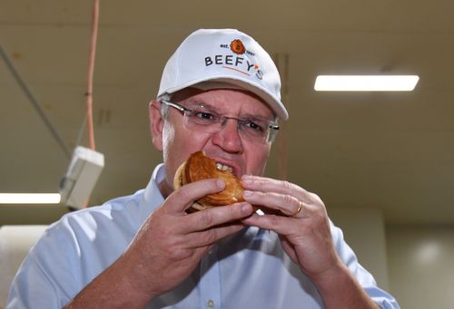 Scott Morrison eats a pie during a visit to the Beefy's Pies factory near Maroochydore on the Sunshine Coast.