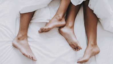 Young couple in underwear lying on bed.