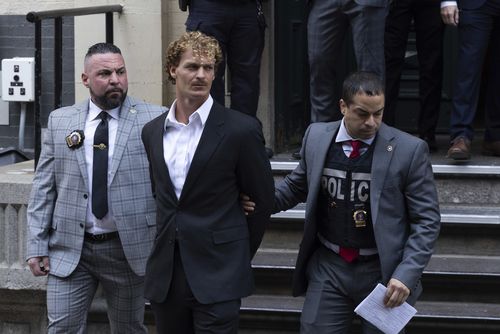 Daniel Penny, center, is walked by New York Police Department detectives detectives out of the 5th Precinct on Friday, May. 12, 2023 in New York. 