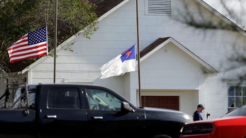 Flags fly at half-staff as law enforcement officials continue to investigate the scene of a shooting. (AAP)