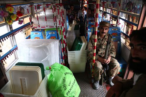 Pakistani Army soldiers sit guard as polling staff collect electoral material for general elections in Karachi. Picture: AAP