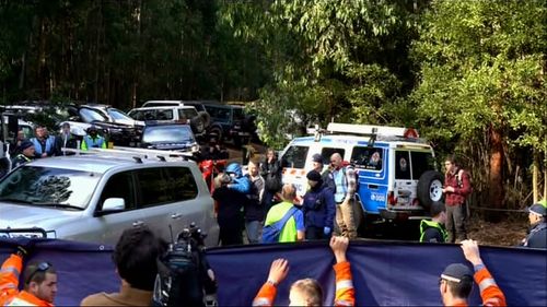 William Callaghan, wearing a blue jacket, is carried across the base camp where searchers had been camping for two nights, while looking for the missing 14-year-old.