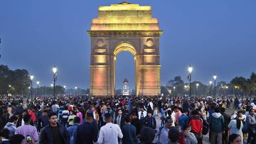 India Gate in New Delhi with a crowd of people celebrating New Year