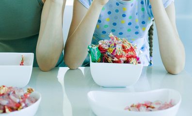 Mother and daughter eating lollies out of a bowl